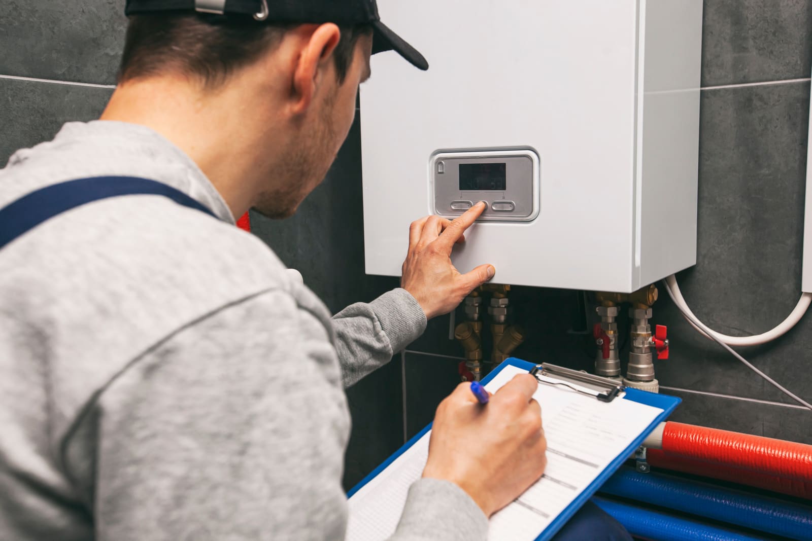 Technicien inspectant un circuit de chauffage en chaufferie