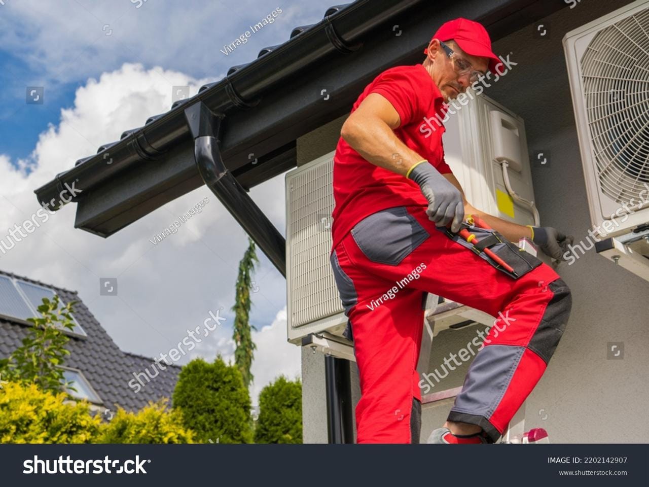 Technicien installant une pompe à chaleur en extérieur